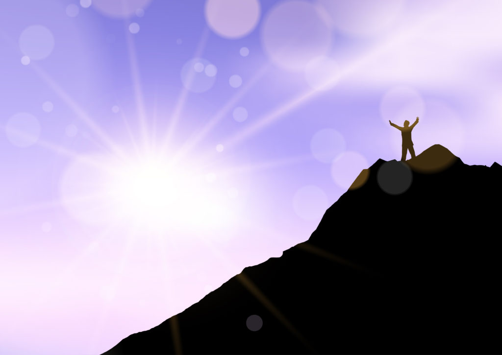 TheREDWords.website/BLOG page. Photo of a man standing on a mountaintop with arms raised toward heaven in thankfulness.