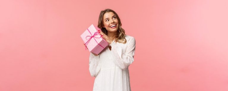 TheREDWords.website/BLOG page. A photo of a teenaged girl smiling as she holds a pink gift wrapped box.