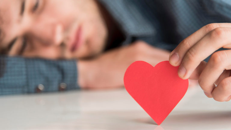 TheREDWords.website/BLOG page. A blurred photo of a man resting his head on a table while holding a cutout red heart.