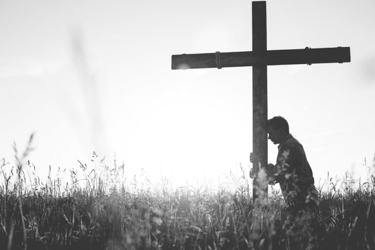 TheREDWords.website/BLOG page. A photo of a man kneeling at the base of a cross.