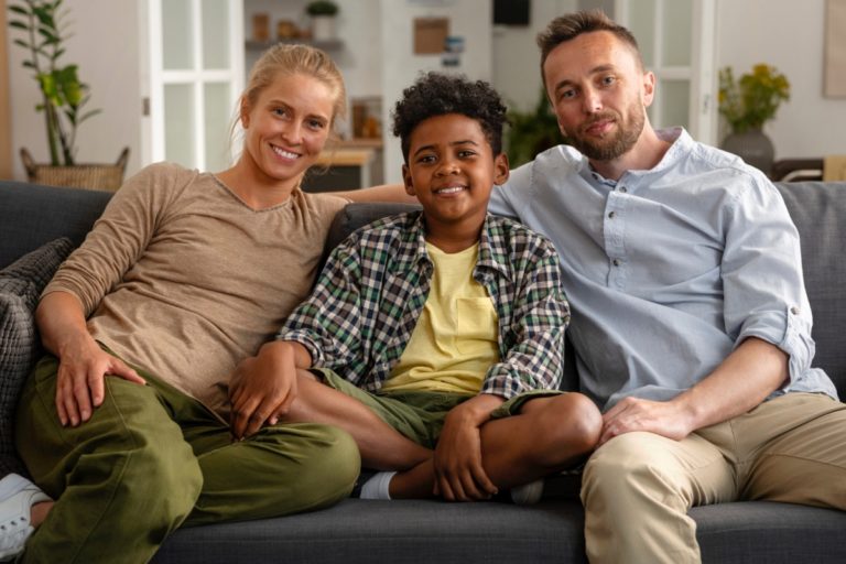 TheREDWords.website/BLOG page. A photo of a mixed race family sitting on the couch.