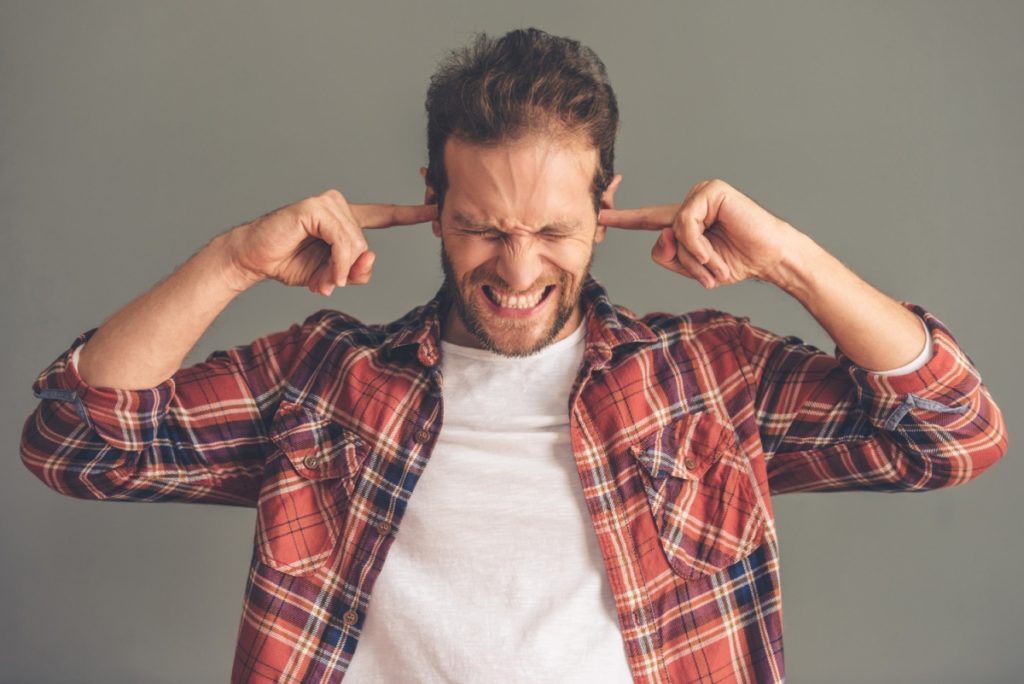 TheREDWords.website/BLOG page. A photo of a man standing with his fingers plugging his ears.