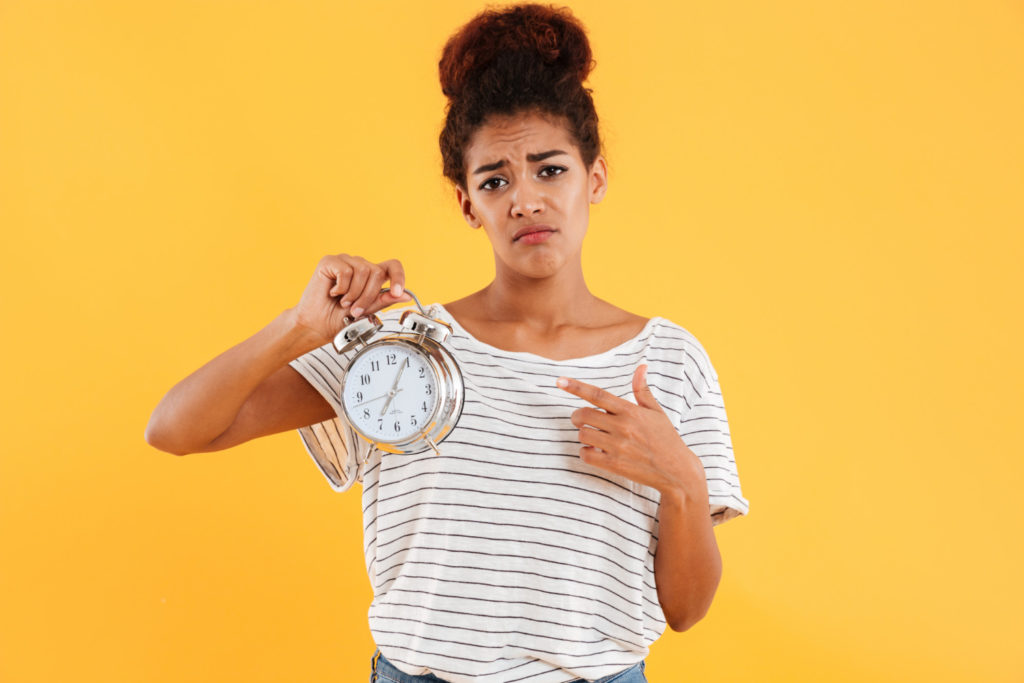 TheREDWords.website/BLOG page. A photo of a woman holding a clock and pointing at it in frustration.