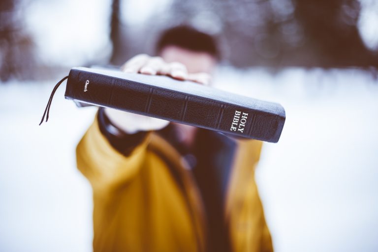 TheREDWords.website/BLOG page. A photo of a man holding the Holy bible up to the camera.