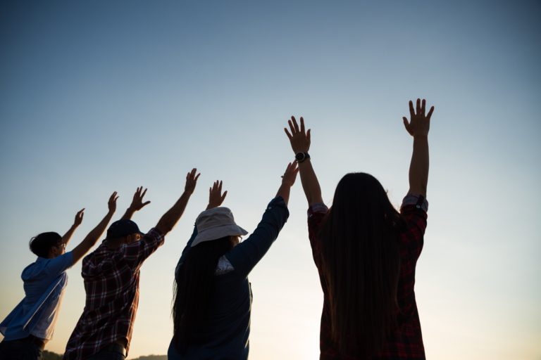 TheREDWords.website/Prayer Starter. A photo of a young people lifting their arms in worship.