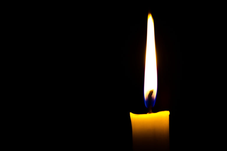 TheREDWords.website/BLOG page. A photo of a solitary lit bright yellow candle in the dark.